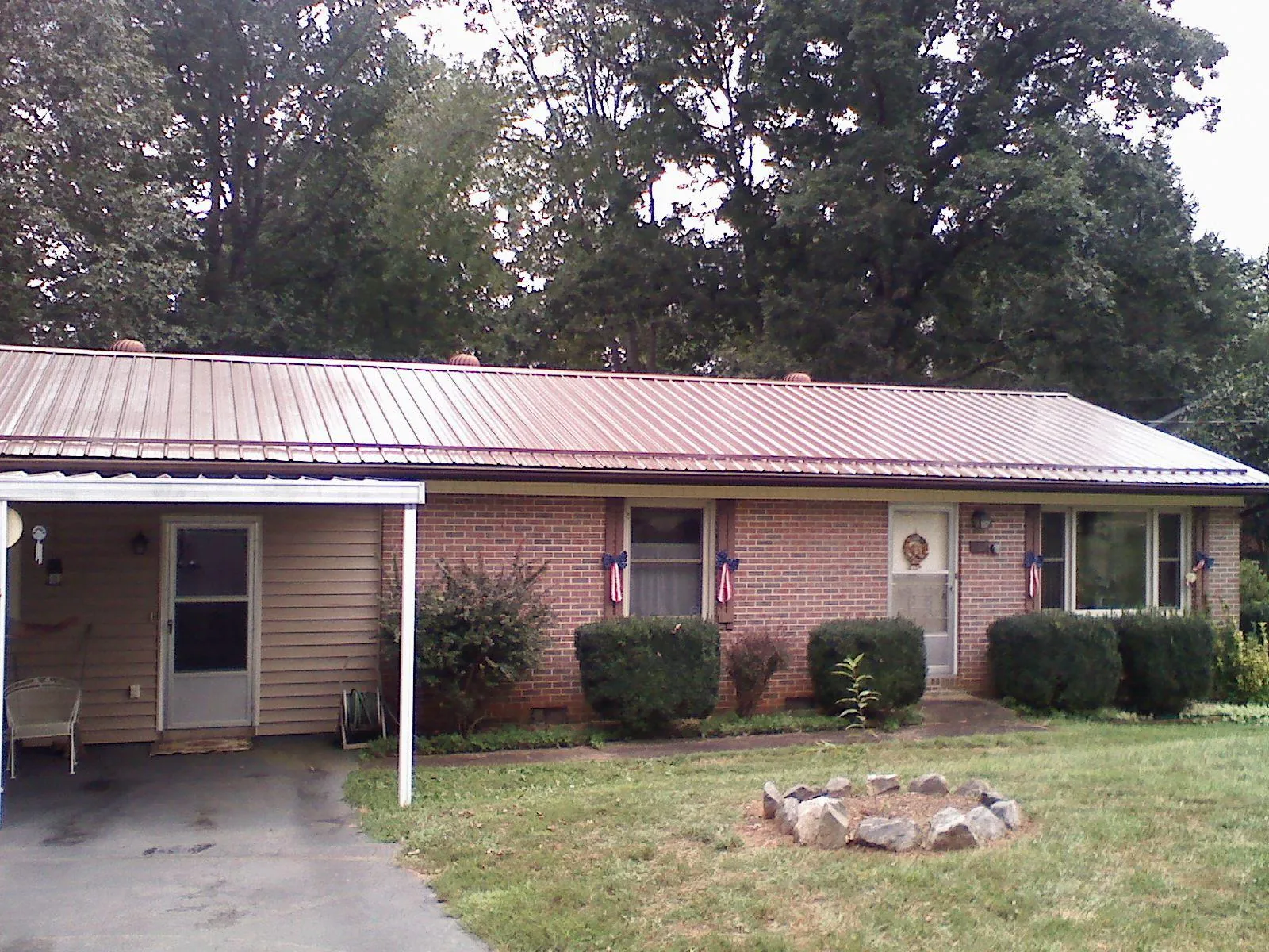 Bronze metal roof and carport on a brick ranch home — Roof Repair work by our crew in Abilene